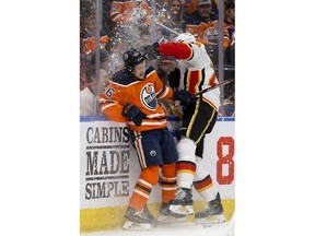 The Edmonton Oilers' Kailer Yamamoto (56) battles the Calgary Flames' Travis Hamonic (24) during first period NHL action at Rogers Place, in Edmonton Wednesday Jan. 29, 2020. Photo by David Bloom