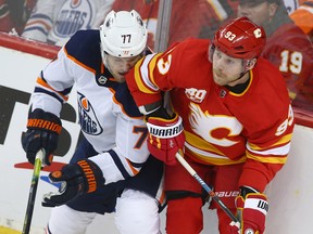 Oilers Osczr Klefbom takes an elbow from Flames Sam Bennett in Calgary on Jan. 11, 2020.