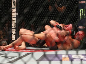 In this Nov. 4, 2017, file photo, Michael Bisping of England is pinned by Georges St-Pierre of Canada in their UFC middleweight championship bout during the UFC 217 event at Madison Square Garden in New York City.