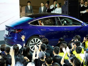 A Tesla China-made Model 3 vehicle owner sits inside a car during a delivery event at Tesla's Shanghai factory in China January 7, 2020.