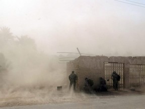 In this file photo taken on April 15, 2008, U.S. soldiers take cover as U.S. Blackhawk helicopters drop troops at a U.S. military base in Salman Pak, south of Baghdad.