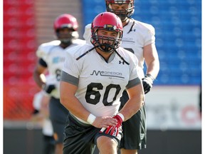 Colleen De Neve/ Calgary Herald CALGARY, AB -- AUGUST 17, 2015 -- University of Calgary Dinos offensive lineman Sean McEwen stretched with teammates during training camp at McMahon Stadium on August 17, 2015. (Colleen De Neve/Calgary Herald) (For  story by Kristen Odland) 00067626A SLUG: 0818-Dinos football