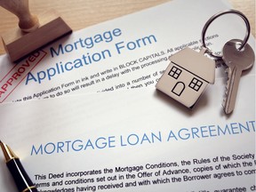 Mortgage loan agreement application with  key on house shaped keyring. Getty Images.