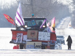 A truck with flags and posters parks near the closed train tracks on the ninth day of a blockade in Tyendinaga, near Belleville, Ont., on Friday Feb. 14, 2020.