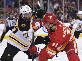 Boston Bruins centre Patrice Bergeron battles with Calgary Flames forward Mikael Backlund at the Saddledome on Feb. 21, 2020.