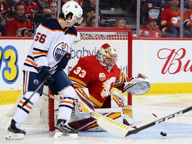 Calgary Flames goalie David Rittich and the Edmonton Oilers Kailer Yamamoto reach for a rebounding puck during NHL action in Calgary on Saturday, February 1, 2020.