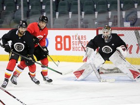 Calgary Flames Oliver Kylington, left and Milan Lucic jostle for position in front of goalie Cam Talbot during team practice in Calgary on Monday, February 3, 2020.  Gavin Young/Postmedia
