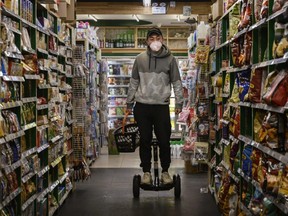 A man wears a protective mask as he rides a segway in a grocery store while shopping in Beijing, China, on Tuesday, Feb. 11, 2020.