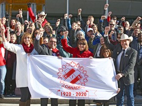 Kinsmen members hold a ceremonial flag during a Centennial flag raising at Calgary City Hall in honour of Kin Canada’s 100th anniversary on Thursday, February 20, 2020. Jim Wells/Postmedia