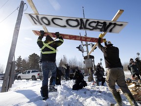 Counter protesters tear down a blockade along the CN rail line near 213 Street and 110 Avenue, in Edmonton Wednesday Feb. 19, 2020. A separate group of protesters had set up the blockade in solidarity with Wet'suwet'en Hereditary Chiefs. Photo by David Bloom