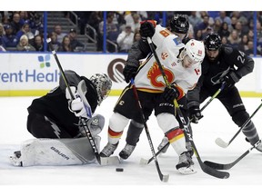 CP-Web.  Calgary Flames left wing Andrew Mangiapane (88) battles with Tampa Bay Lightning defenseman Zach Bogosian (24) and center Blake Coleman (20) for control of the puck in front of goaltender Andrei Vasilevskiy (88) during the first period of an NHL hockey game Saturday, Feb. 29, 2020, in Tampa, Fla.