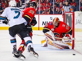 Flames goaltender David Rittich guards the net as Calgary Flames defenseman Michael Stone and San Jose Sharks center Dylan Gambrell battle for the puck during the second period at Scotiabank Saddledome on Feb. 4, 2020.