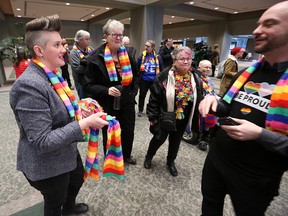 Organizer Pam Rocker hands out rainbow scarves to supporters of a motion before council banning conversion therapy in Calgary on Monday, Feb. 3, 2020.