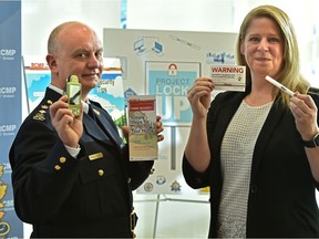 Supt. Peter Tewfik, Alberta RCMP officer in charge of crime reduction strategies, left, and Jennifer Kee, Alberta RCMP community engagement and outreach specialist, mark the one-year anniversary of Project Lock Up at RCMP K Division in Edmonton on Monday, Feb. 10, 2020. The initiative creates a framework that enables the RCMP and its enforcement and citizen-led stakeholders to place a spotlight on repeat victims of property crime.