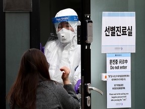 A medical professional conducts an interview with a suspected patient with coronavirus (COVID-19) at a preliminary testing facility at the National Medical Center where patients suspected of contracting coronavirus (COVID-19) are assessed on February 24, 2020 in Seoul, South Korea. (Chung Sung-Jun/Getty Images)