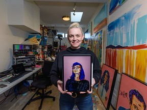 Artist Mandy Stobo poses for a photo while holding the portrait she has painted of Alberta's chief medical officer of health Dr. Deena Hinshaw at her home studio on Friday, March 20, 2020. Azin Ghaffari/Postmedia