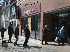 People line-up outside an SAQ location in Westmount while practising social distancing on Saturday, March 21, 2020.