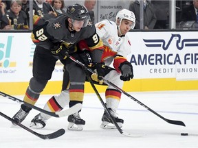 LAS VEGAS, NEVADA - OCTOBER 12:  Tomas Nosek #92 of the Vegas Golden Knights and Mikael Backlund #11 of the Calgary Flames fight for the puck in the second period of their game at T-Mobile Arena on October 12, 2019 in Las Vegas, Nevada. The Golden Knights defeated the Flames 6-2.