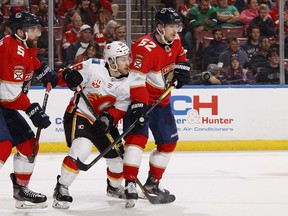 SUNRISE, FL - MARCH 1: MacKenzie Weegar #52 of the Florida Panthers defends against Andrew Mangiapane #88 of the Calgary Flames in front of the net during second period action at the BB&T Center on March 1, 2020 in Sunrise, Florida. (Photo by Joel Auerbach/Getty Images)
