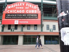 People walk in front of Wrigley Field on what was to be opening day for Major League Baseball on March 26, 2020 in Chicago, Illinois.