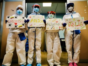Medical personnel hold a banner with the name of their homelands, during the coronavirus disease (COVID-19) outbreak, in Cremona, Italy, March 29, 2020, in this picture obtained from social media. (FRANCESCA MANGIATORDI/ FRANCE_EXA via REUTERS)