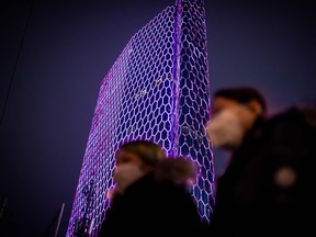 People wearing a protective facemask to protect against the COVID-19 coronavirus walk past the Intercontinental hotel in Beijing on Feb. 24, 2020. (NICOLAS ASFOURI/AFP via Getty Images)