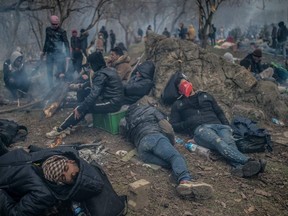 Migrants wait near the buffer zone at Turkey-Greece border, at Pazarkule, in Edirne district, on February 29, 2020.