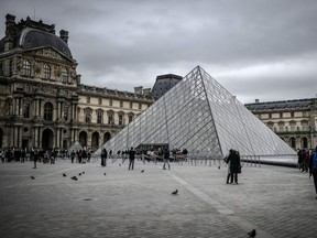 In this file photo taken on February 28, 2020 people visit the Louvre Pyramide in Paris.