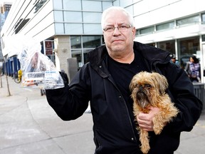 Lonnie Nomeland and his dog Tessa with their daily collection of needles he finds around the supervised consumption site at the Sheldon M. Chumir Health Centre in Calgary on Thursday, March 5, 2020.