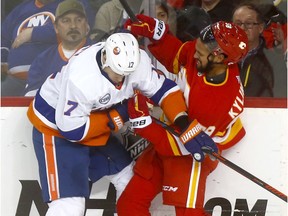 Calgary Flames Oliver Kylington battles New York Islanders Matt Martin in third period action at the Scotiabank Saddledome in Calgary on Wednesday February 20, 2019. Darren Makowichuk/Postmedia