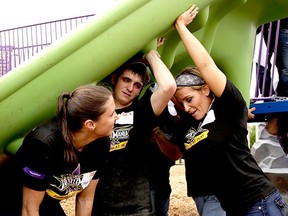 Nattie (right) holding up a slide, with Stephanie McMahon and a volunteer. (Supplied Photo)