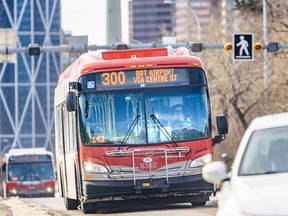 A Calgary transit bus driver covers her face as she drives through Centre Street on Tuesday, March 17, 2020.
