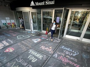 A woman exits Mount Sinai Hospital in Manhattan past messages of thanks written on the sidewalk during the outbreak of the coronavirus disease (COVID19) in New York City, April 7, 2020. (REUTERS/Mike Segar)