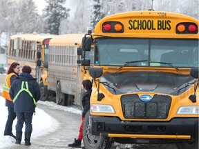 School buses are seen lined up outside Sir John Franklin School NE before picking up students from school. Thursday, December 12, 2019.
