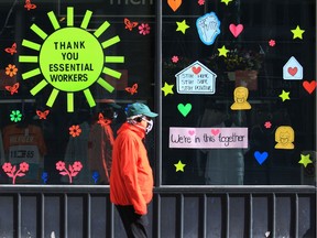 A man walks past signs thanking essential workers while getting some exercise on Stephen Avenue Mall in Calgary on Wednesday morning, April 29, 2020.  Gavin Young/Postmedia