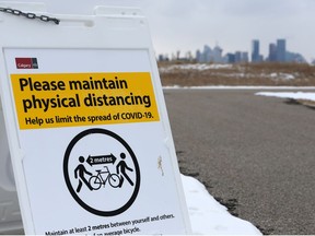 A sign at the start of a pathway reminds users about physical distance precautions as Calgary continued to deal with the COVID-19 pandemic on Thursday, April 2, 2020. Gavin Young/Postmedia