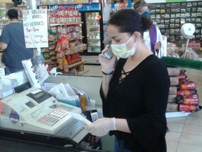Johanna Ramirez works in her grocery store in Fort Lupton, Colorado, where she is concerned that not enough customers are taking precautions, like wearing masks, to stop the spread of COVID-19, on April 23, 2020.