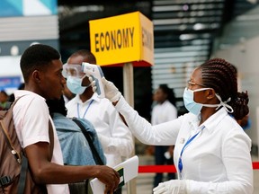 A health worker checks the temperature of a traveller as part of the coronavirus screening procedure at the Kotoka International Airport in Accra, Ghana January 30, 2020.