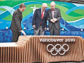 (L) Claude Bernier, RONA's executive vice president, marketing and customer  innovations, (C) John Furlong, VANOC CEO, and (R)Gordon Campbell, premier of British Columbia unveil 2010 Olympic and Paralympic Winter Games Victory Ceremonies podium and costume designs of the Victory Ceremonies February 2, 2010 at Main Press Centre in downtown Vancouver.