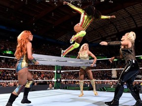 Naomi jumps towards Natalya off of a ladder held by Becky Lynch and Charlotte Flair.