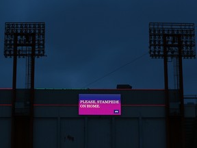 A sign on the otherwise darkened McMahon Stadium encourages Calgarians to stay home during the COVID-19 pandemic on Thursday, April 2, 2020.