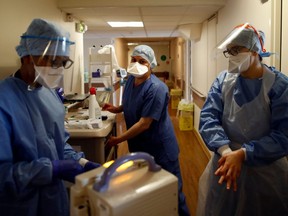 Nurses use medical equipment as they tend to patients infected with COVID-19 at the intensive care unit of the Peupliers private hospital in Paris, Tuesday, April 7, 2020.