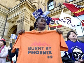 A member of Union Local 70130 holds a shirt during a protest over problems with the Phoenix pay system outside the Office of the Prime Minister and Privy Council in Ottawa on Thursday, Oct. 12, 2017.