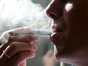 File photo shows a man exhaling from an electronic cigarette.