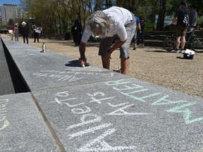 Denise Roy, along with other artists from the Alberta Arts Matter Coalition, raised their voices against grant deferrals by drawing in chalk outside the Alberta Legislature in Edmonton, May 28, 2020.