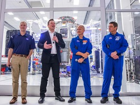 In this file photo taken on Oct. 10, 2019, SpaceX founder Elon Musk (second from left) addresses the media alongside NASA Administrator Jim Bridenstine (left), and astronauts Douglas Hurley (second from right) and Robert Behnken (right), during a press conference announcing new developments of the Crew Dragon reusable spacecraft, at SpaceX headquarters in Hawthorne, Calif.