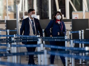 Flight attendants wear face masks at Santiago International Airport, in Santiago, on May 5, 2020 during the new coronavirus pandemic.