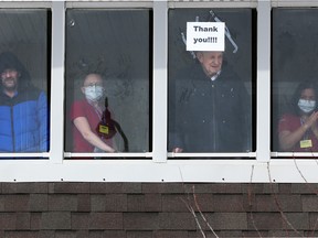 Residents and staff wave to supporters outside the McKenzie Towne Continuing Care Centre on April 1, 2020.