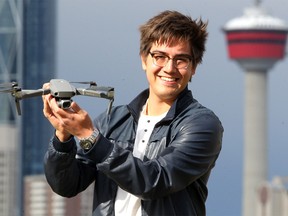 Videographer Eric Gonzalez poses for a photo with his drone in front of the Calgary skyline on Sunday, May 3, 2020. Brendan Miller/Postmedia