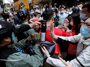 Anti-government demonstrators scuffle with riot police during a lunch time protest as a second reading of a controversial national anthem law takes place in Hong Kong, China May 27, 2020.